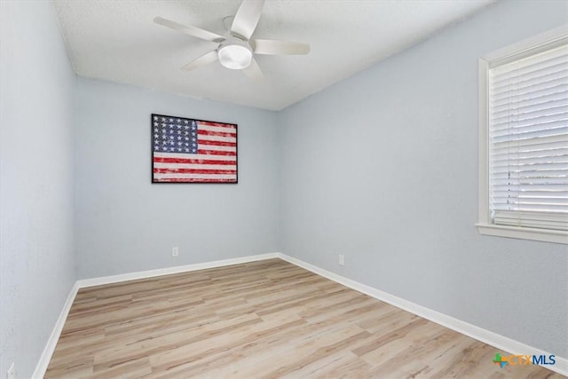 unfurnished room with ceiling fan, baseboards, and wood finished floors