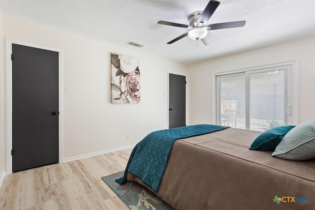 bedroom with light wood finished floors, visible vents, baseboards, access to outside, and a textured ceiling