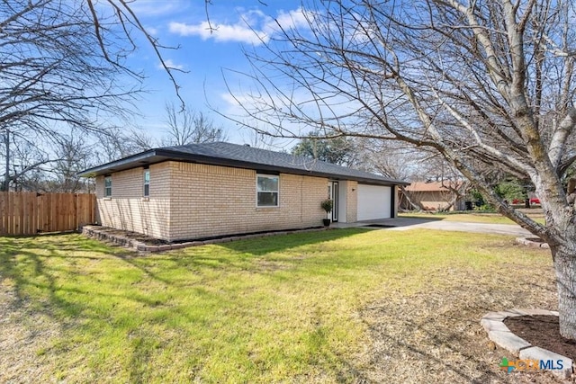 view of property exterior with a garage, concrete driveway, fence, a yard, and brick siding