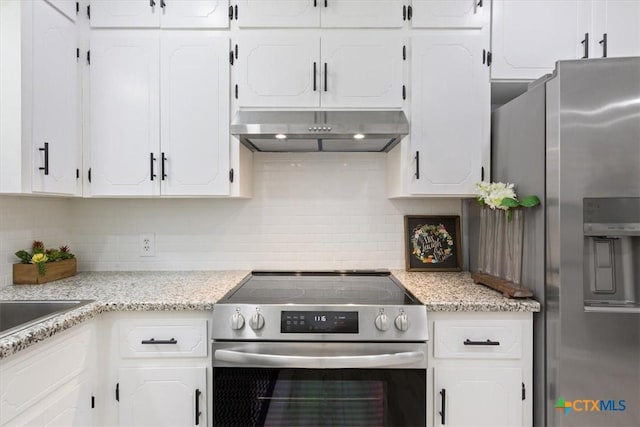 kitchen with white cabinets, decorative backsplash, light stone counters, appliances with stainless steel finishes, and under cabinet range hood