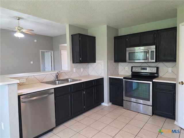 2803 Lindsey Dr, Copperas Cove, TX 76522 - kitchen featuring appliances with stainless steel finishes, dark cabinetry, backsplash, light countertops, and a textured ceiling
