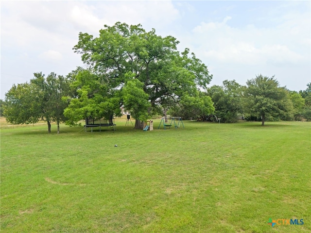 view of yard featuring a playground and a trampoline