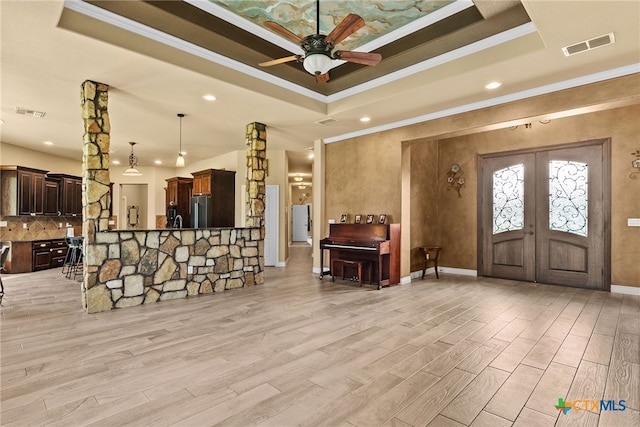 interior space with a raised ceiling, stainless steel fridge, and light hardwood / wood-style flooring