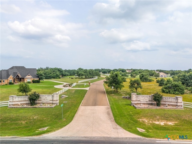 view of community with a rural view and a yard