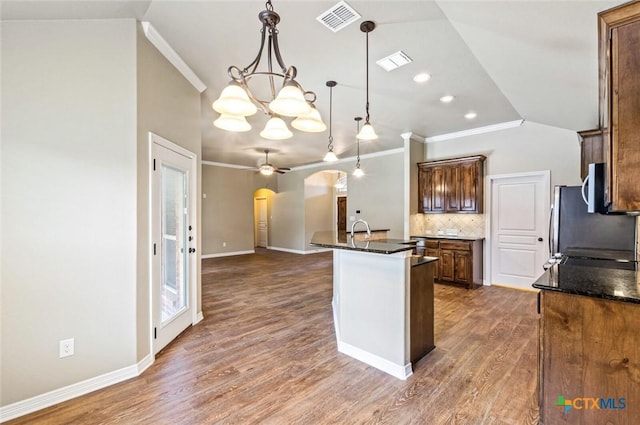 1617 Shadow Canyon Dr, Temple, TX 76502 - kitchen with arched walkways, vaulted ceiling, crown molding, decorative backsplash, and wood finished floors