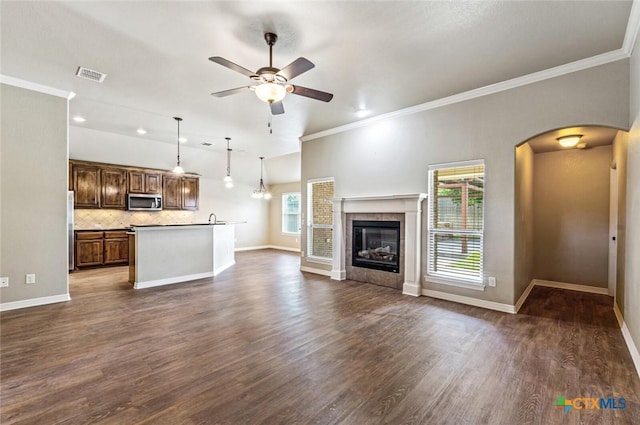 1617 Shadow Canyon Dr, Temple, TX 76502 - unfurnished living room with a ceiling fan, arched walkways, lofted ceiling, dark wood-type flooring, and a fireplace