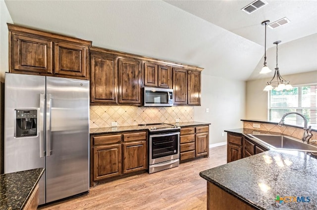 1617 Shadow Canyon Dr, Temple, TX 76502 - kitchen with appliances with stainless steel finishes, light wood-style floors, vaulted ceiling, tasteful backsplash, and pendant lighting