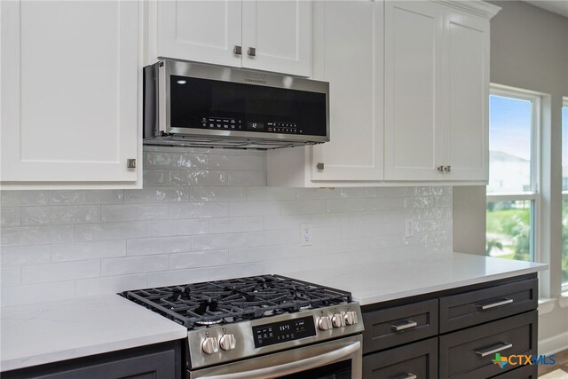 kitchen featuring white cabinetry, decorative backsplash, and stainless steel appliances