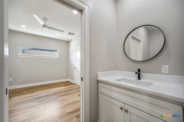 bathroom with wood-type flooring, ceiling fan, and vanity