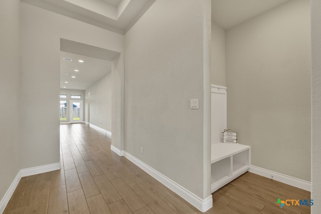 corridor with hardwood / wood-style flooring