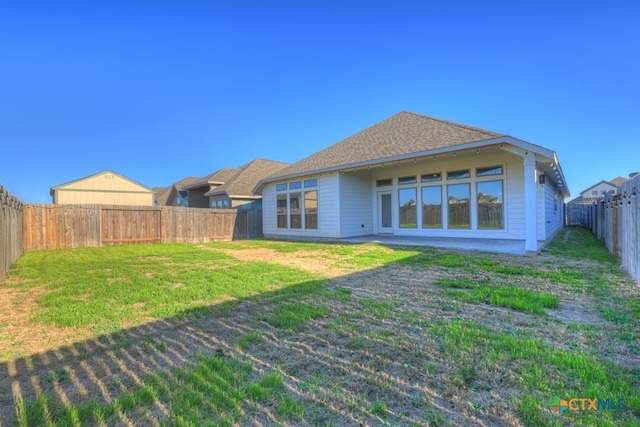 rear view of house featuring a yard