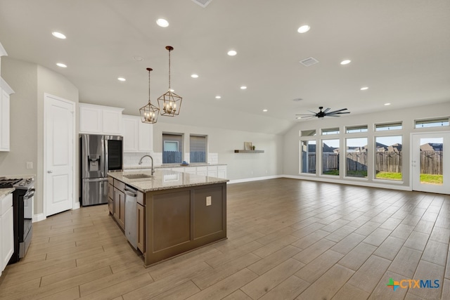 kitchen with pendant lighting, white cabinets, a kitchen island with sink, and stainless steel appliances