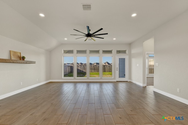 unfurnished living room featuring hardwood / wood-style flooring, ceiling fan, and vaulted ceiling