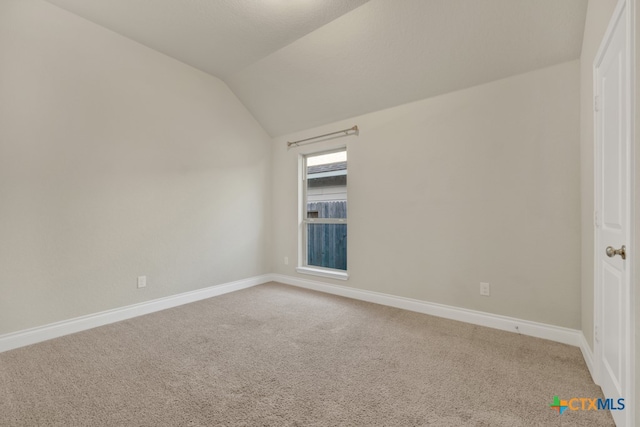 unfurnished room with carpet flooring and lofted ceiling