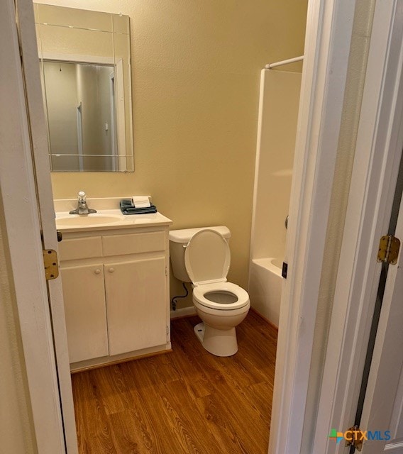 full bathroom featuring hardwood / wood-style flooring, vanity, toilet, and shower / bathing tub combination