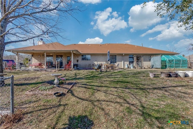 back of property featuring an outdoor structure and a lawn