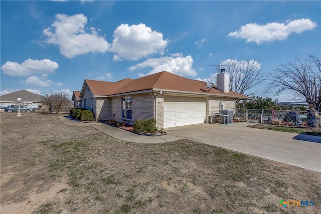 view of front of home featuring central AC unit and a garage