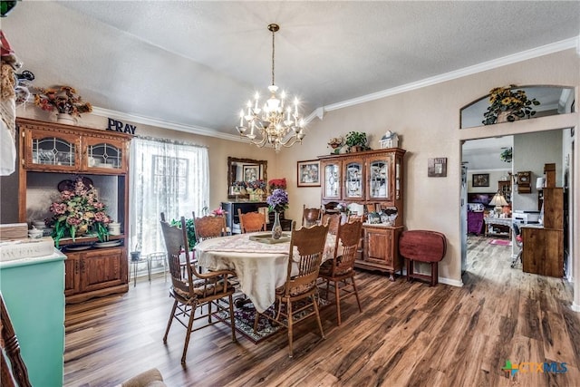 dining area featuring an inviting chandelier, crown molding, dark hardwood / wood-style floors, and a textured ceiling