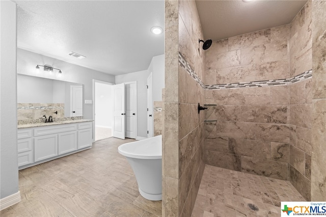 bathroom featuring vanity, plus walk in shower, and tile walls