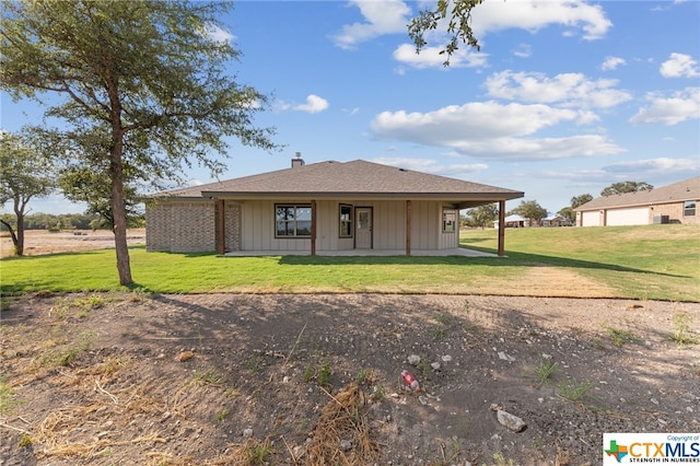 rear view of property featuring a yard