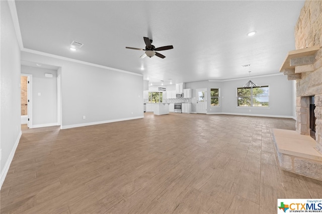 unfurnished living room featuring a fireplace, hardwood / wood-style flooring, ceiling fan, and crown molding