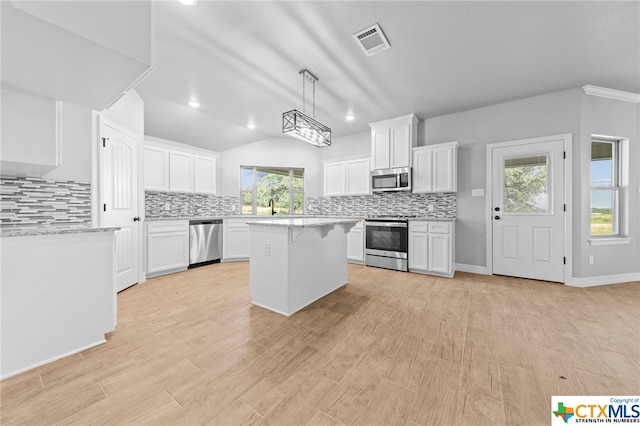 kitchen featuring white cabinets, a wealth of natural light, stainless steel appliances, and light wood-type flooring