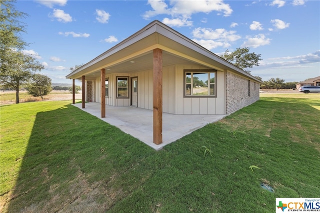 rear view of property with a lawn and a patio area