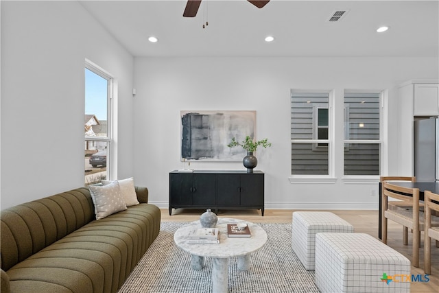 living room with ceiling fan and light hardwood / wood-style floors