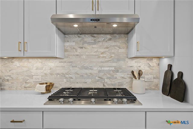 kitchen featuring stainless steel gas cooktop, decorative backsplash, and exhaust hood