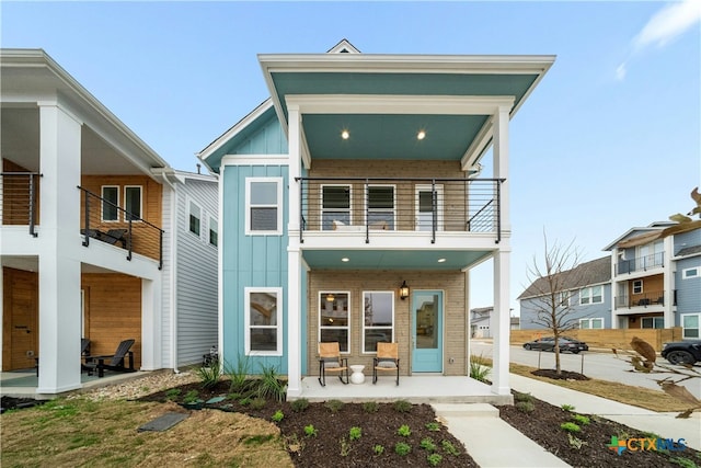 back of house featuring a balcony and a porch