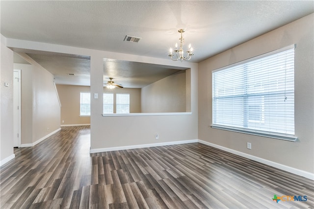 empty room with dark wood-type flooring, ceiling fan with notable chandelier, and a textured ceiling