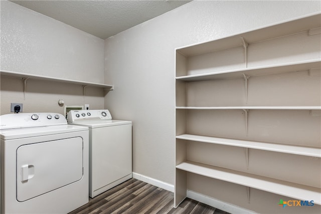 laundry area with washing machine and dryer, a textured ceiling, and dark hardwood / wood-style flooring