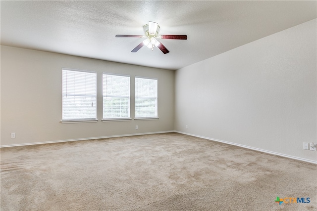 unfurnished room featuring a textured ceiling, light colored carpet, and ceiling fan