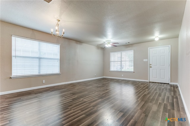 spare room with dark wood-type flooring, a textured ceiling, and ceiling fan with notable chandelier