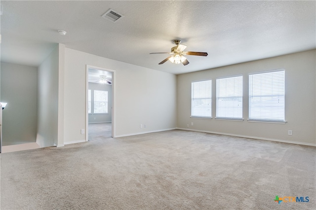 unfurnished room featuring ceiling fan, a textured ceiling, and light colored carpet