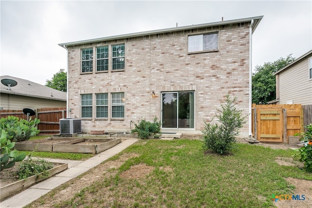 back of house with a lawn and central AC