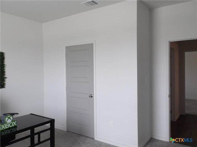 interior space featuring visible vents, baseboards, and light carpet