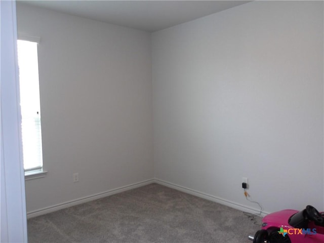 unfurnished room with baseboards, carpet floors, and a healthy amount of sunlight