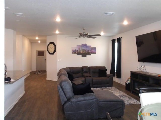living room with baseboards, a ceiling fan, visible vents, and dark wood-style floors