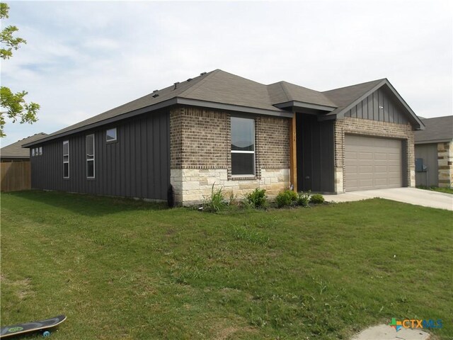 view of front of home featuring a garage, driveway, board and batten siding, a front yard, and brick siding