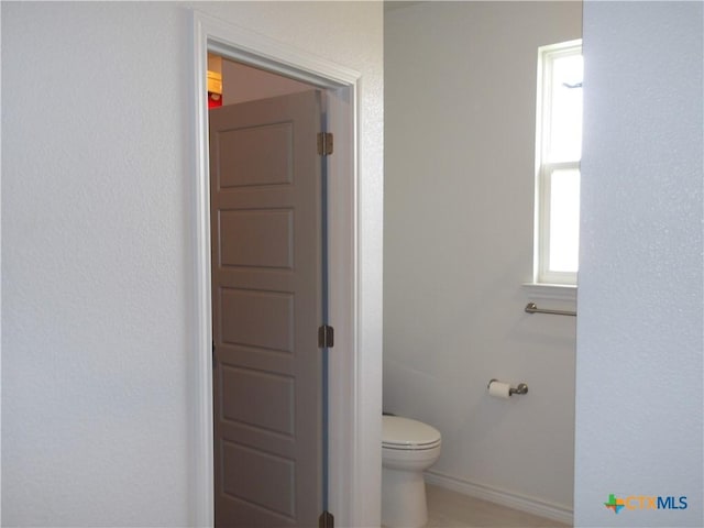 bathroom with baseboards and toilet