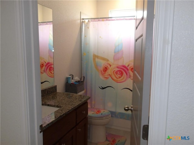 full bath featuring a textured wall, vanity, a shower with shower curtain, and toilet