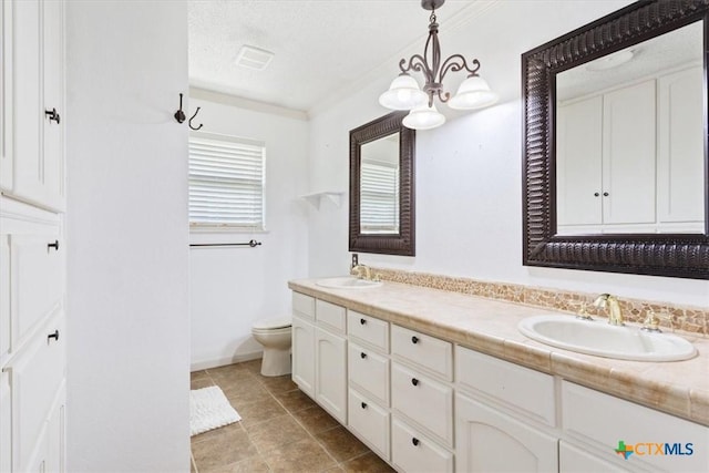 full bathroom featuring visible vents, toilet, double vanity, a textured ceiling, and a sink