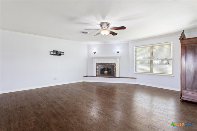 unfurnished living room featuring dark wood finished floors, ornamental molding, a ceiling fan, and a premium fireplace