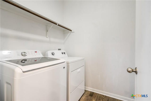 clothes washing area featuring washer and clothes dryer and dark wood-type flooring