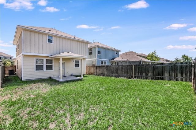 back of house with central air condition unit, a yard, and a patio