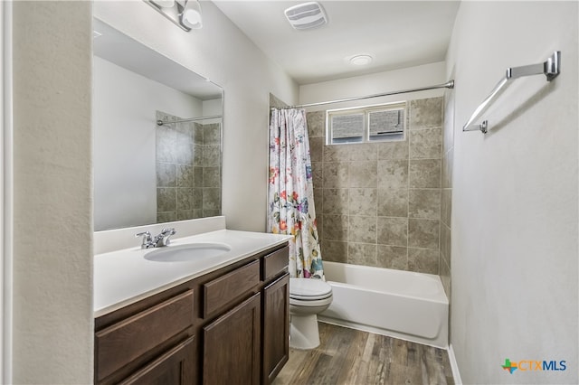 full bathroom featuring hardwood / wood-style flooring, toilet, vanity, and shower / bath combination with curtain