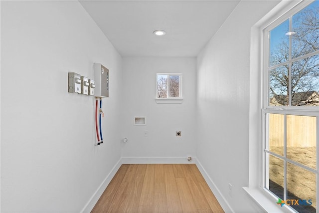 laundry area with hookup for a washing machine, a wealth of natural light, hookup for an electric dryer, and light wood-type flooring