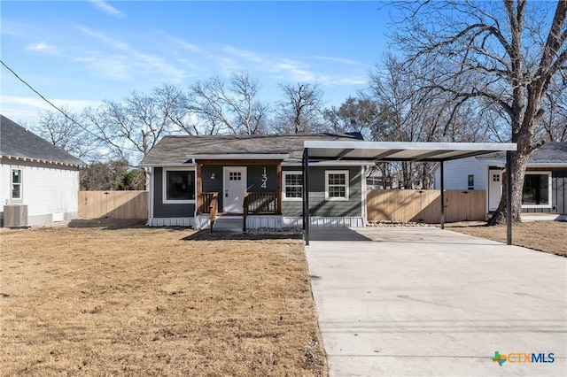 view of front facade with cooling unit, a front lawn, a carport, and covered porch