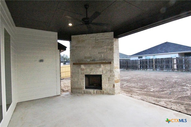 view of patio / terrace featuring ceiling fan and an outdoor stone fireplace